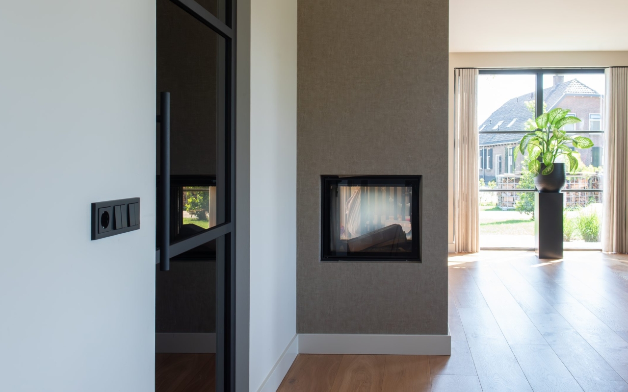 Een doorkijkhaard tussen de keuken en woonkamer